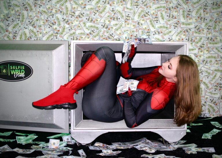 Cosplayer dressed as Spiderman and surrounded by money