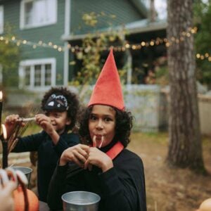 Two kids wearing Halloween costumes and eating treats