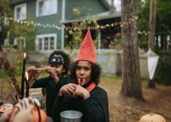Two kids wearing Halloween costumes and eating treats