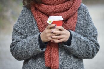 Person wearing a wool coat and knitted scarf