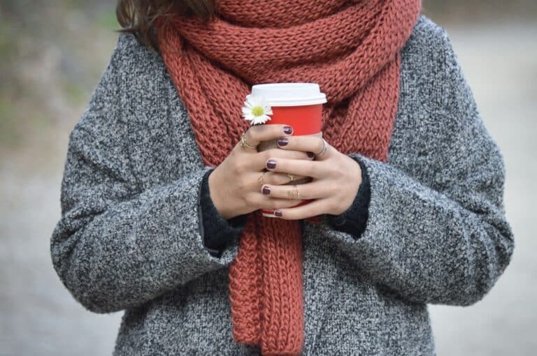 Person wearing a wool coat and knitted scarf