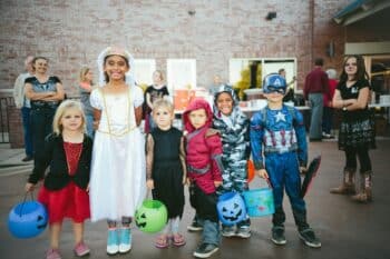 Children wearing varied Halloween costumes at an outdoor gathering