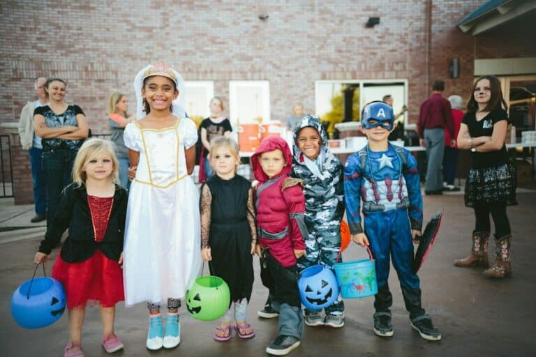 Children wearing varied Halloween costumes at an outdoor gathering