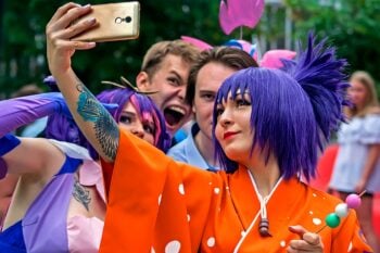 Cosplayers taking a group selfie outdoors