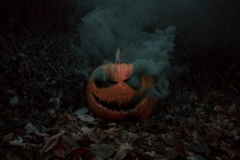 Carved Halloween pumpkin with smoke rising around it