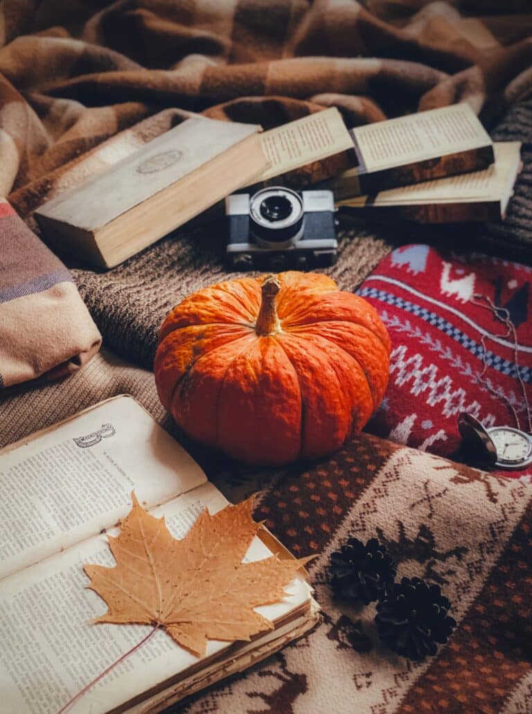 An autumn pumpkin resting beside books