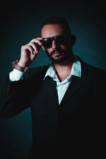 Man wearing a black suit and sunglasses
