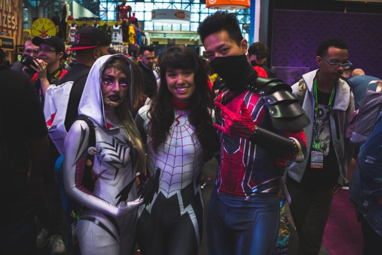 Three cosplayers posing together in colorful costumes
