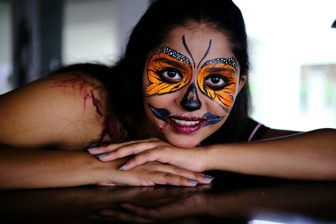 Colourful butterfly face paint with dark theatrical details