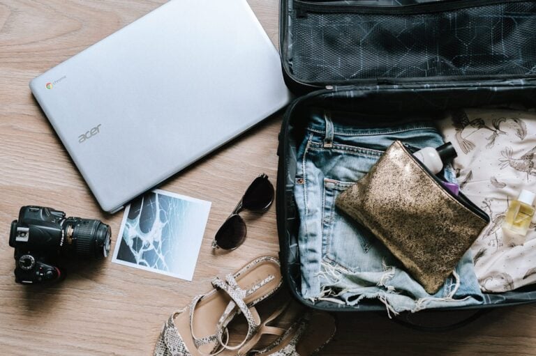 Open suitcase with folded clothes and travel accessories