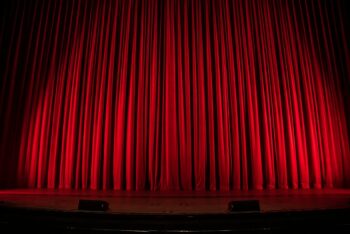 Red velvet curtains covering a theatre stage