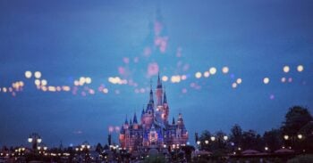 Disney castle illuminated at dusk