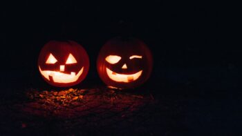 Two illuminated jack-o'-lanterns against a dark background